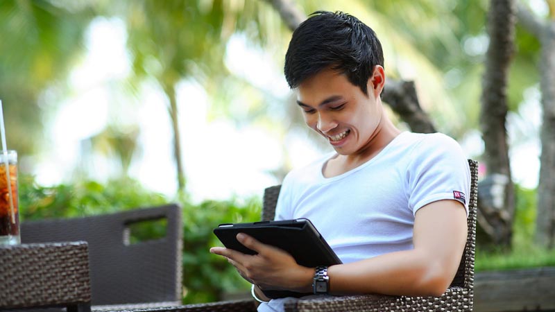 man working with tablet A man browsing English teaching jobs in Cambodia with his tablet