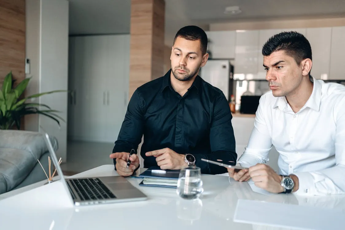 Two people reviewing apartment listings together on a laptop