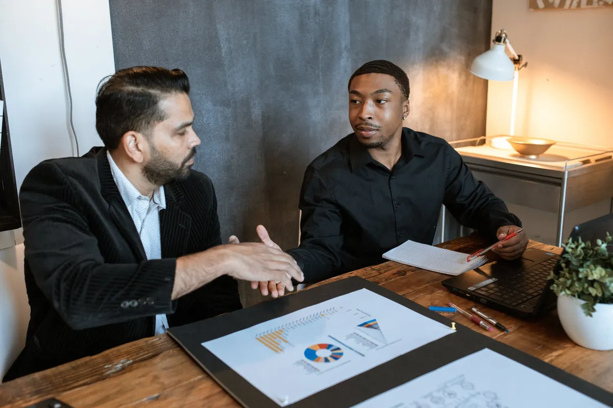 Two professionals reviewing charts and reports at a desk