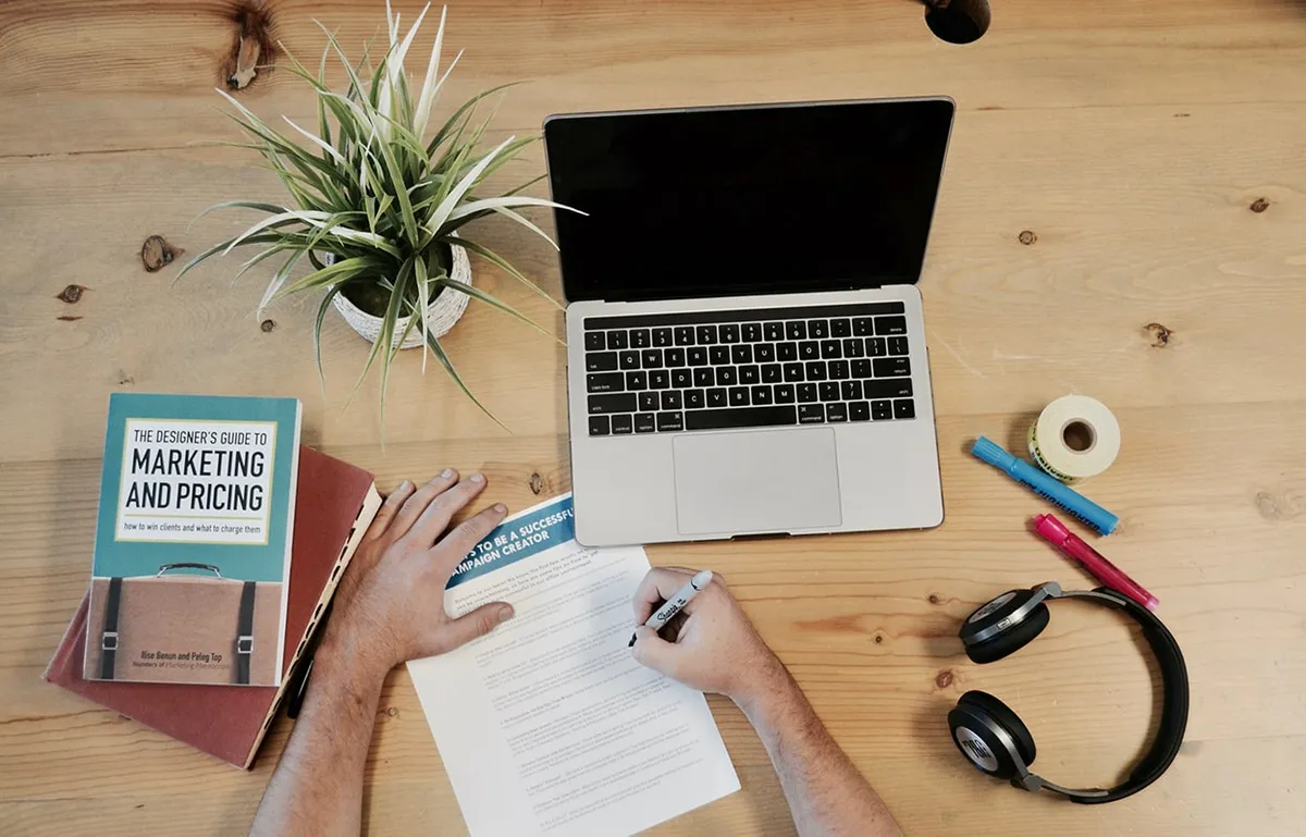 A marketer writing down strategies for a multifamily digital marketing campaign