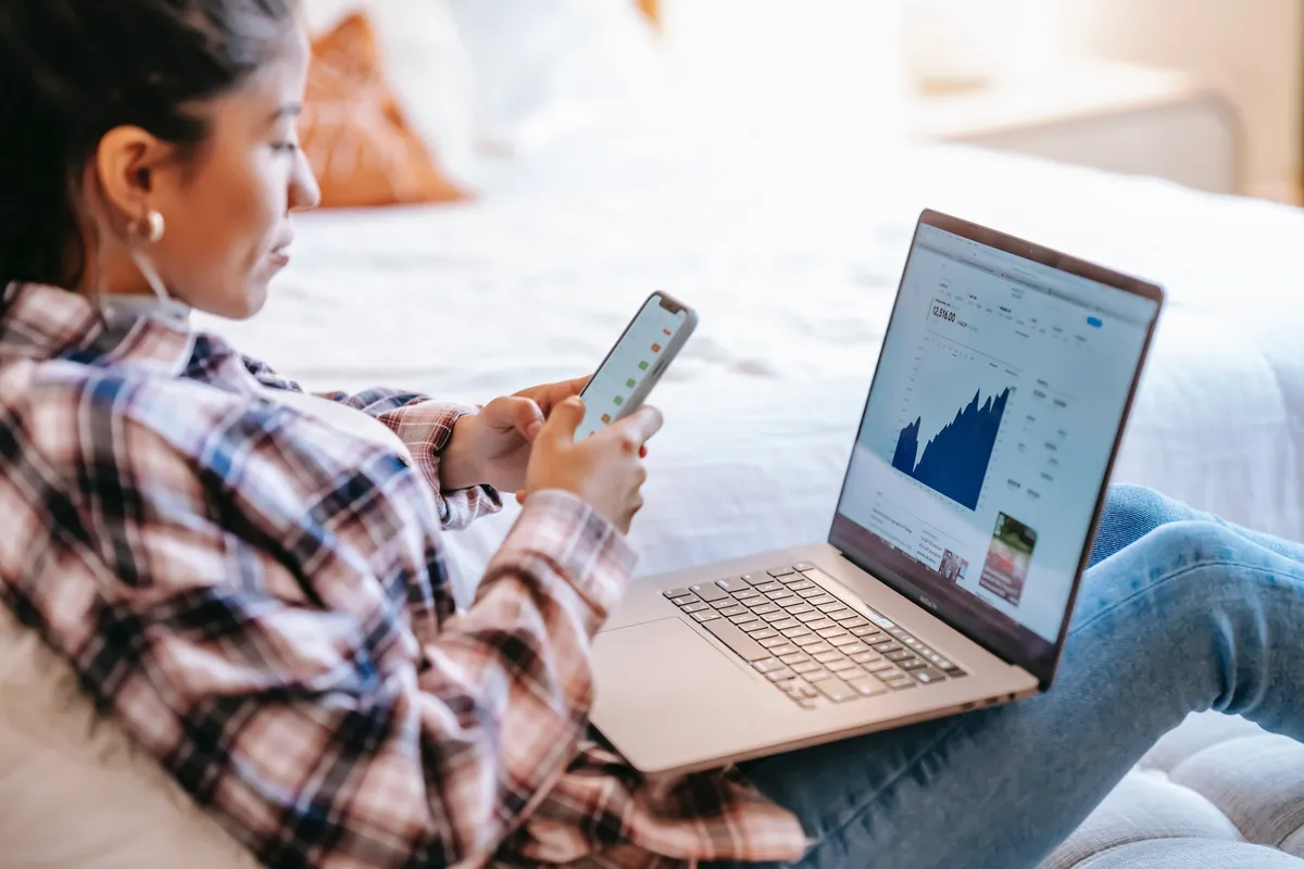 A mortgage SEO specialist checking search results data on a laptop and a smartphone