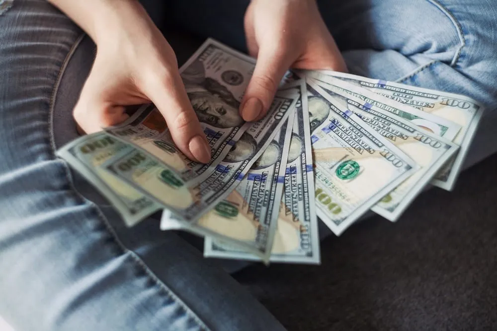 Close-up of hands fanning out a stack of US dollar bills