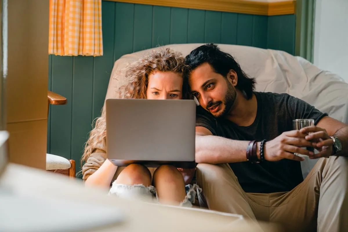 Loving couple using laptop on floor