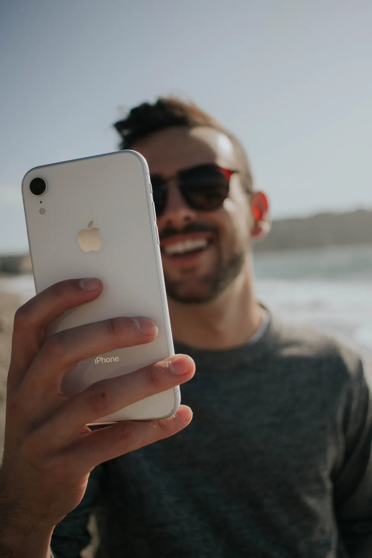 Man smiling as he browses a mobile-optimized website.
