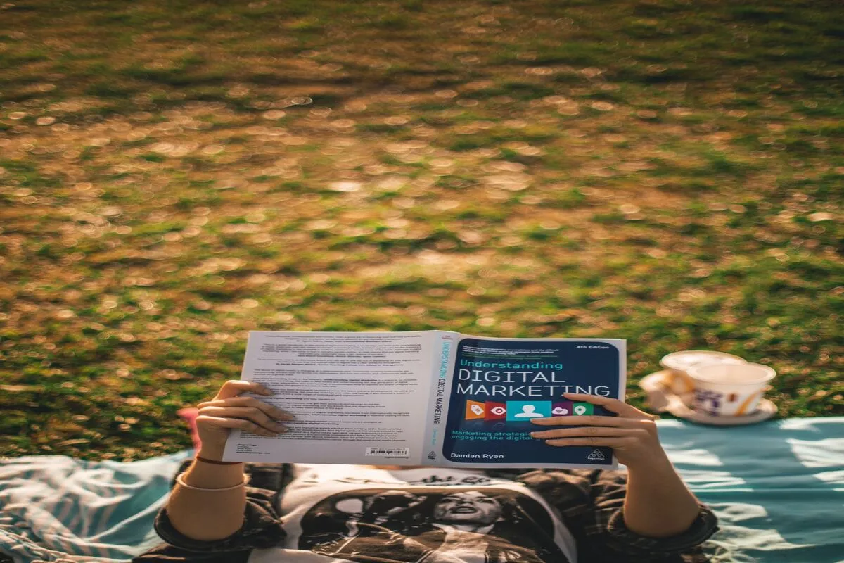 Person holding up a book for digital marketing.