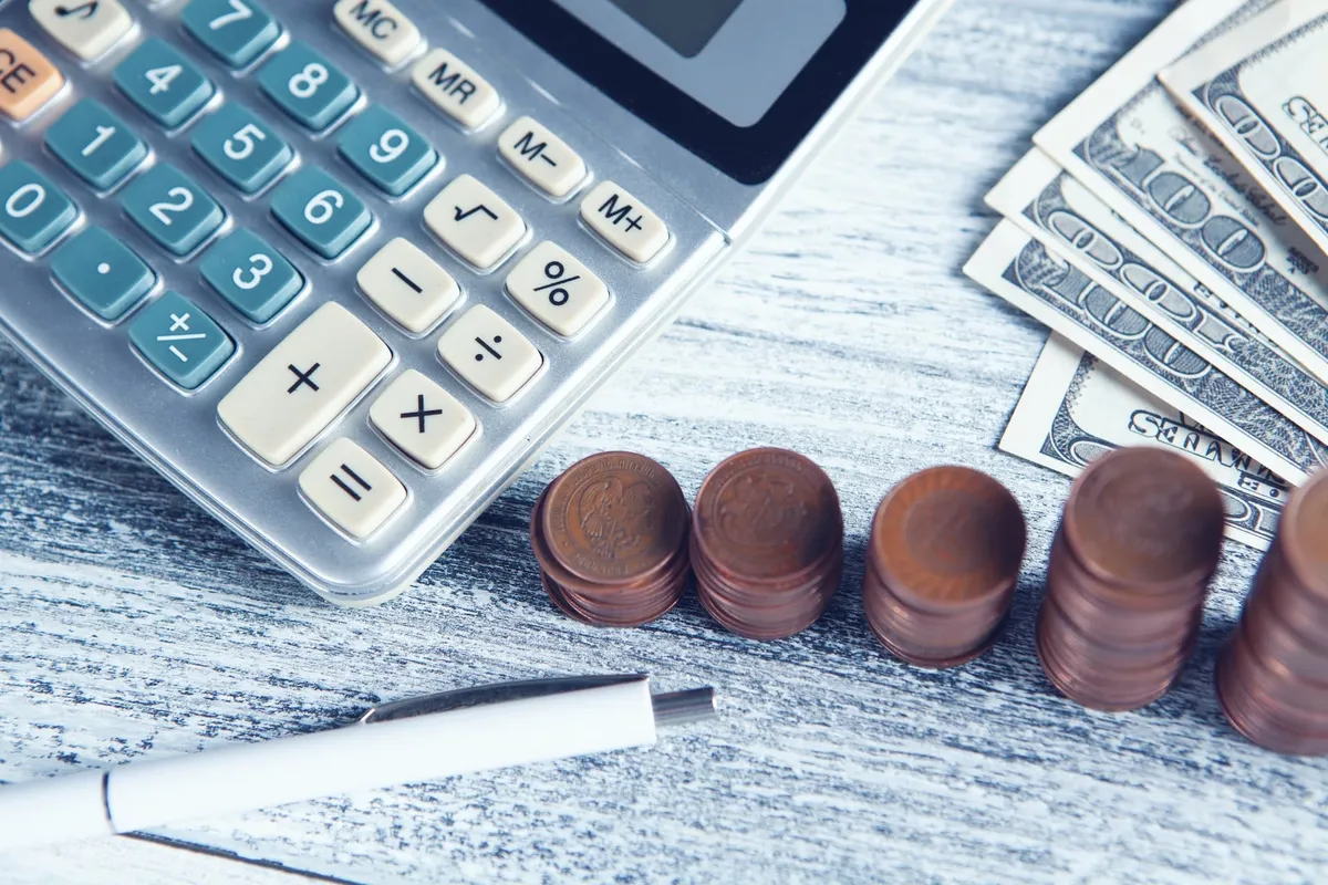 Calculator and money on a desk.