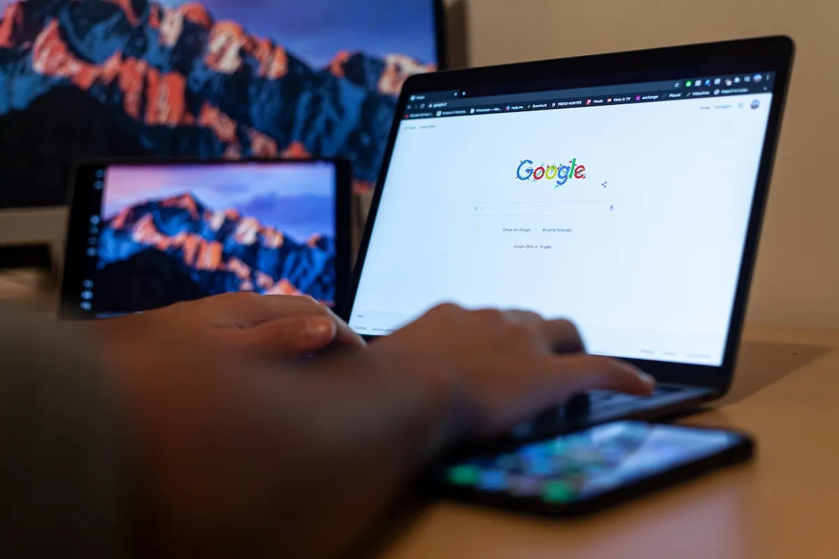 Person using a laptop with the Google homepage open.