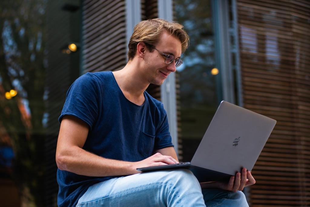 man writing a blog on a laptop