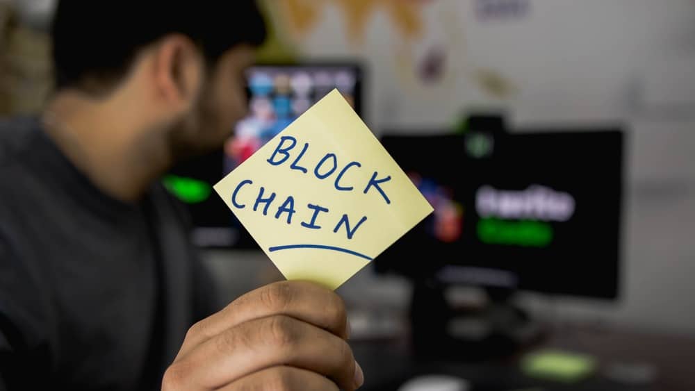 Realtor holding up a Blockchain inscribed note