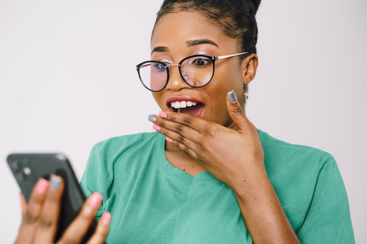 Shocked-woman-in-glasses-looking-at-cellphone-screen
