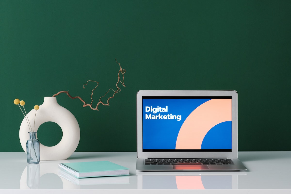 Silver-laptop-on-white-desk-with-digital-marketing-label-on-screen