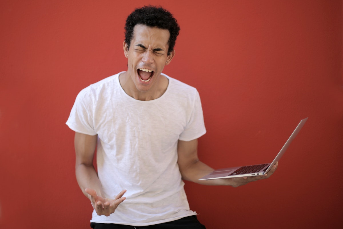 Young-ethnic-male-with-laptop-screaming
