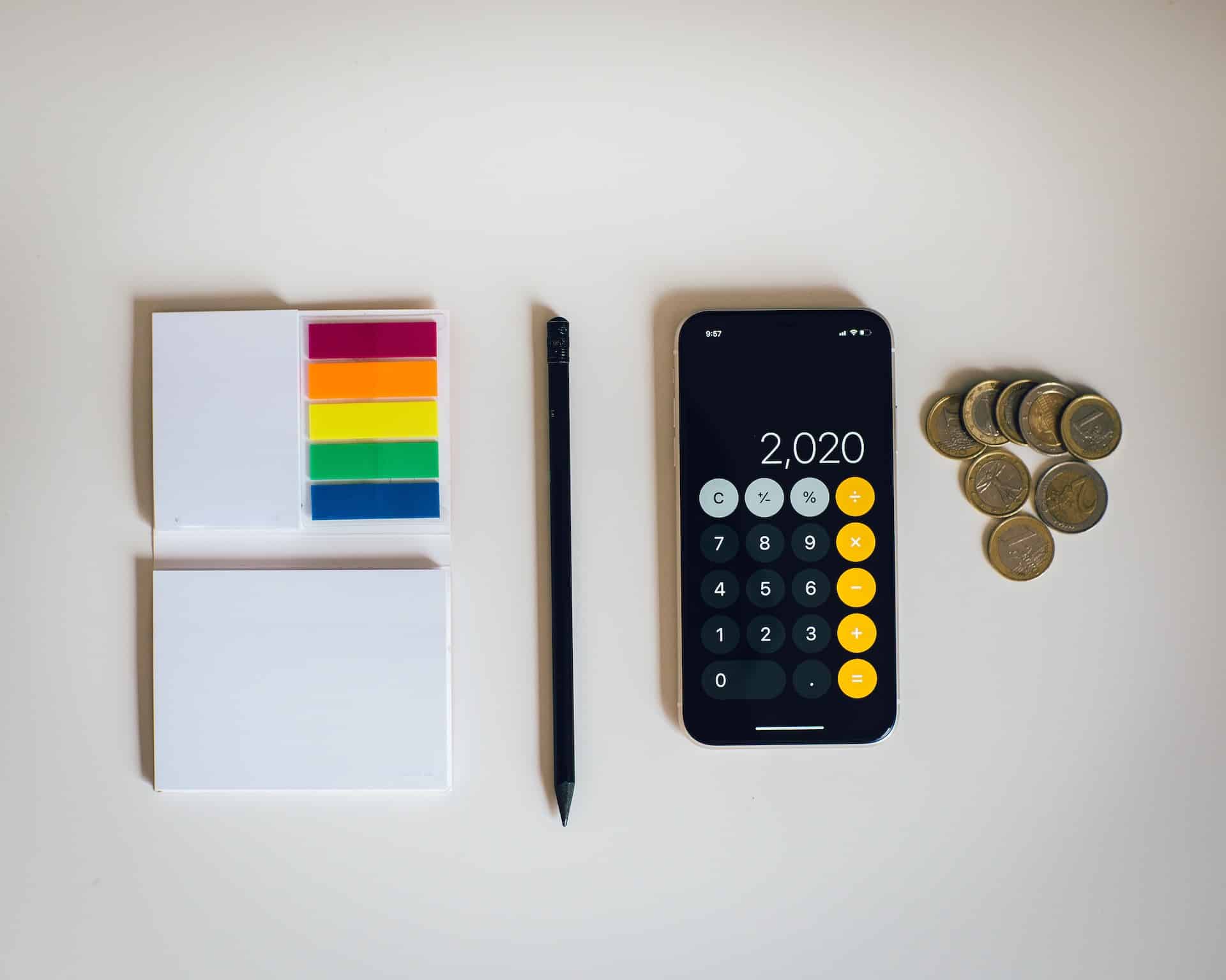Note stickers, a pen, coins, and a smartphone on a white background.
